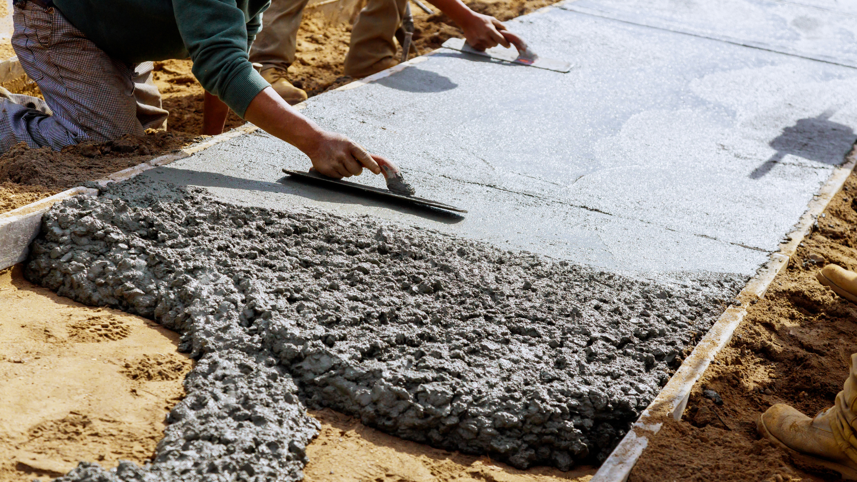 A man laying a slab of concrete on the ground