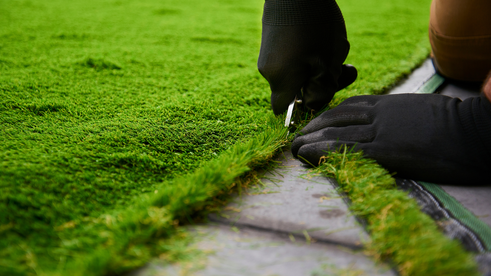 A person cutting grass with a pair of scissors